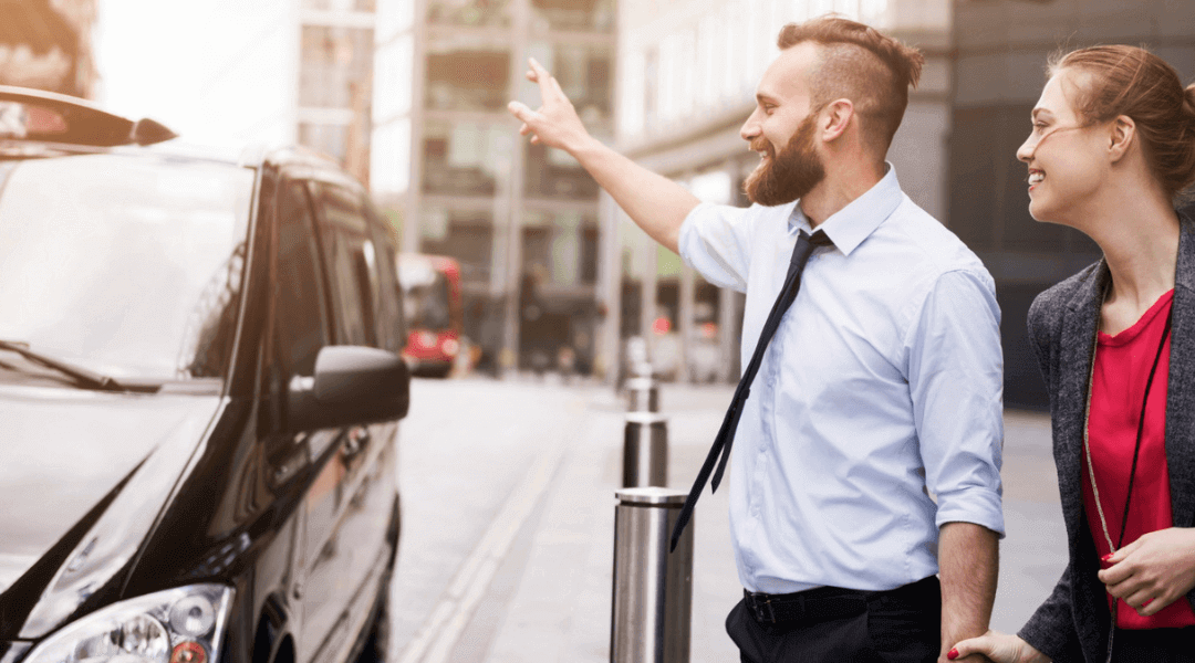 A man and woman are next to a shiny black car, enjoying their time together.