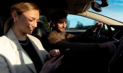 A man and woman in a car, each looking at their cell phones, seemingly unaware of their surroundings.